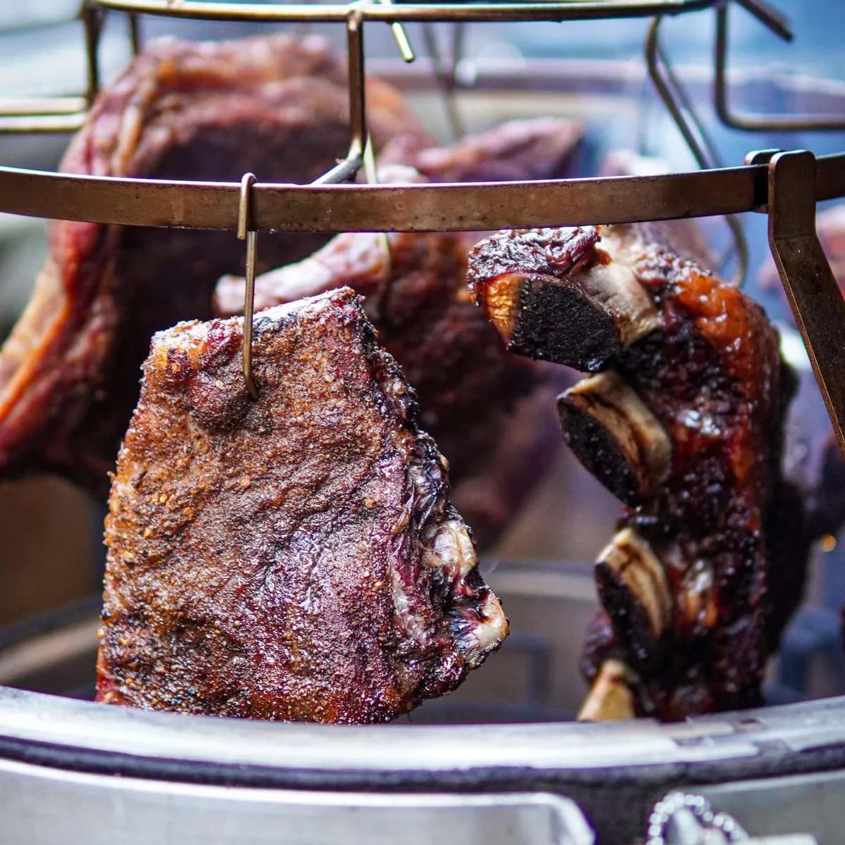 Geräucherte Rinderrippen hängen am Smoke Set im MONOLITH Kamado