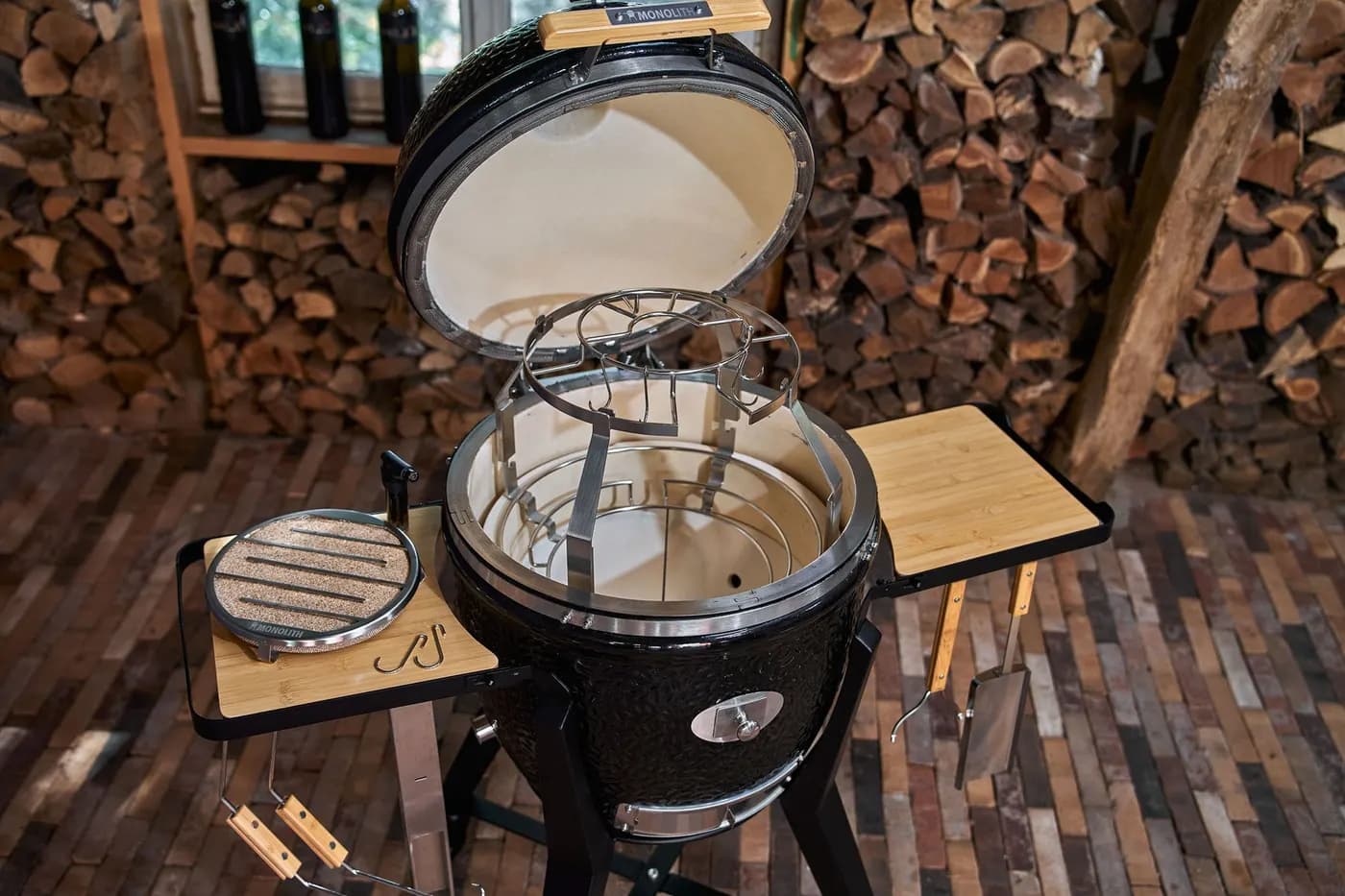 Geöffneter MONOLITH Kamado mit eingesetztem Smoke Set, daneben der Kaltrauchgenerator auf dem Seitentisch