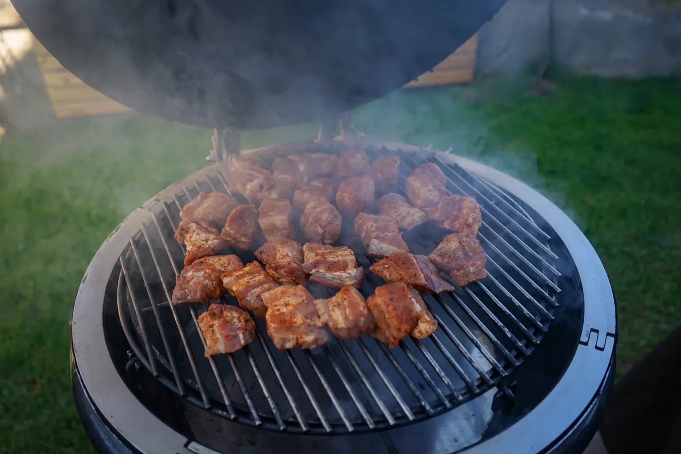 Würfel vom Schweinebauch garen im Rauch auf dem Rost eines MONOLITH Kamados